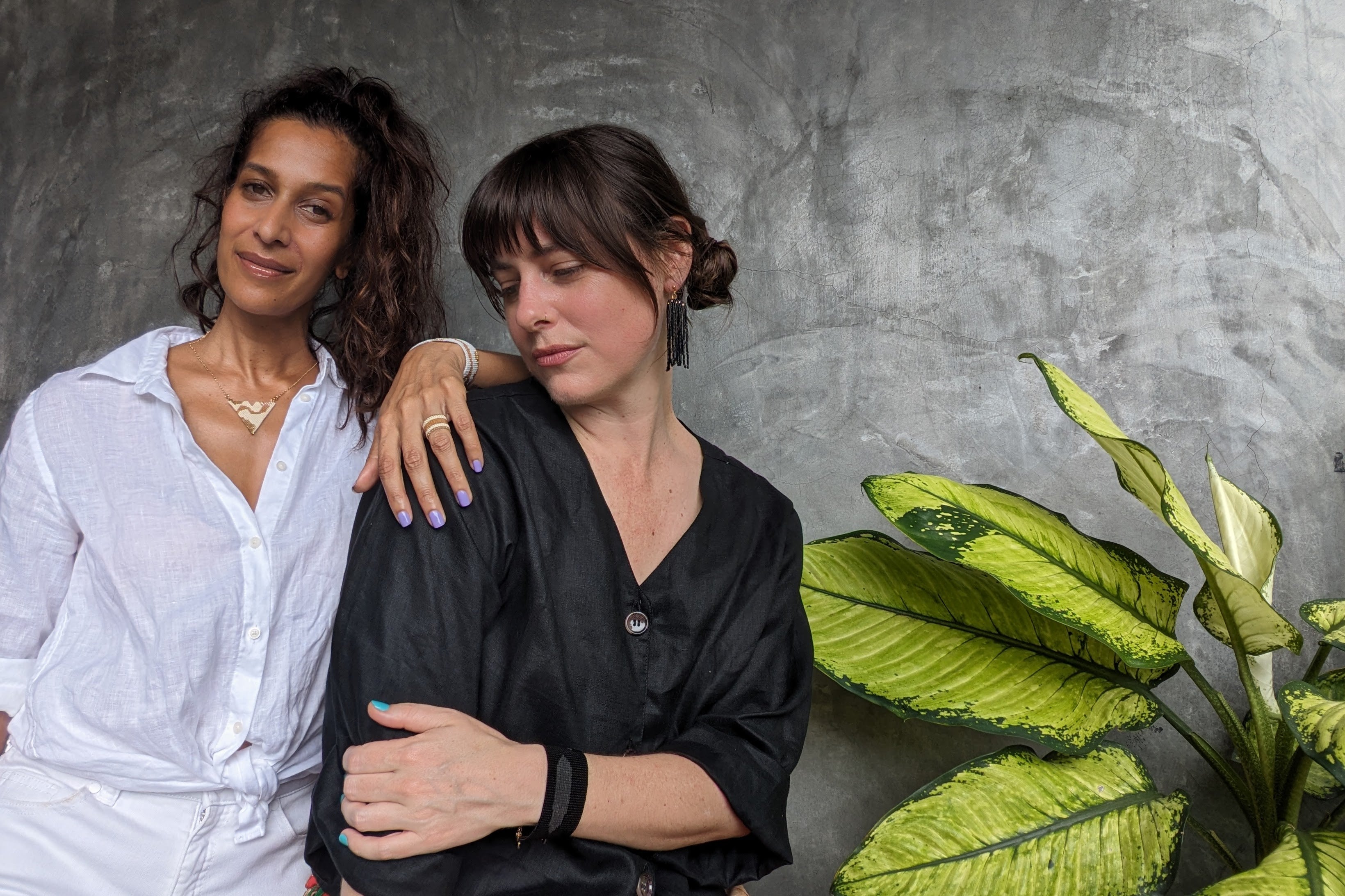 Two women wearing wearing pepper and pollen jewellery